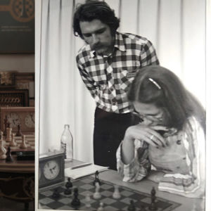 Tvådelad bild. På ena sidan en ung kvinna som tittar på ett schackbräde. På andra sidan en svartvit bild av en ung kvinna som spelar schack. En man står bakom henne och tittar på.