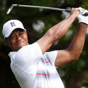Tiger Woods katsoo golflyöntinsä perään.