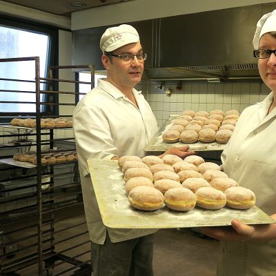 Kaksi leipuria käsissään pellilliset munkkeja