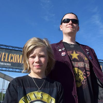Isä ja poika Guns N' Rosesin keikkapaikan pääportin edessä