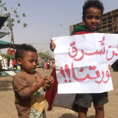 "Stjäl inte vår revolution", står det på det plakat som en liten sudanesisk pojke håller upp under de fortsatta protestern i Khartoum fredagen den 12 april