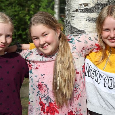 Kolme neljäsluokkalaista tyttöä yhteiskuvassa