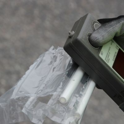 Poliisin kädessä alkometri ja puhallutuspillejä.
