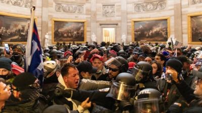 Poliser och Trumpanhängare slåss med varandra inne i en sal i kongressbyggnaden i Washington.