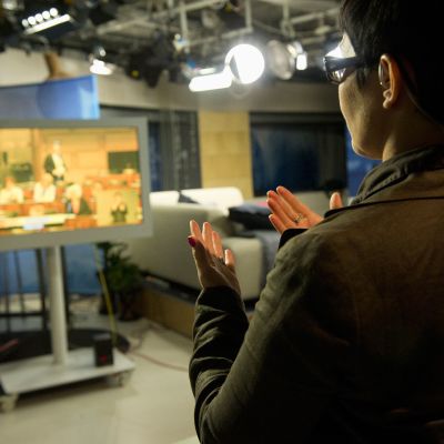 Eduskunnan kyselytuntia tulkataan televisiossa.