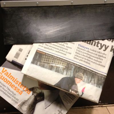 Sanomalehtiä ja aikauslehti postiluukussa