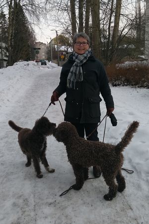 Inger Tallqvist med de italienska tryffelhundarna Pino och Rosso. En kvinna med två hundar i koppel.