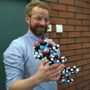 Markus Linder pitää kädessään molekyylimallia.