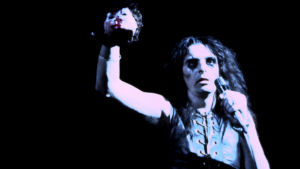 Alice Cooper pitelee irtonaista vauvanuken päätä lavalla vuonna 1972