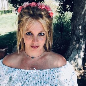 Britney Spearsin itsestään jakama kuva Instagramissa. Britney Spears poseeraa kukkaseppele päässään kuvassa pihalla.