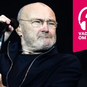 Phil Collins håller i en mikrofon som är i en mikrofonställning.