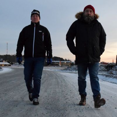 Roger Hakalax och Janne Salonen går på en grusväg i ett vintrigt landskap i Kimito centrum.