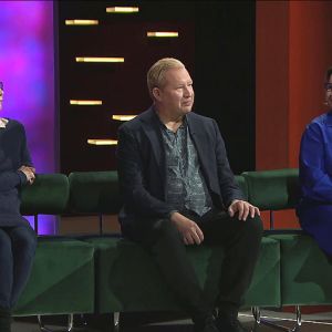 Kaksi naista ja yksi mies istuvat vihreällä sohvalla. 