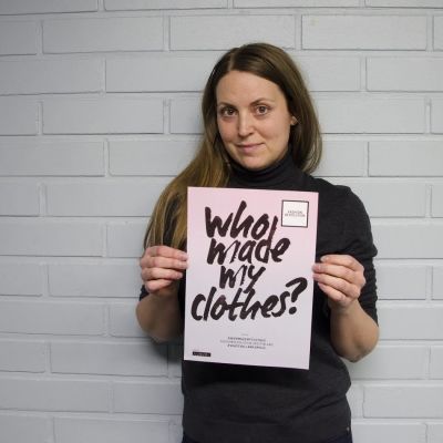 Sarah Jussila från Fashion Revolution håller upp en skylt där det står "Who made my clothes?"