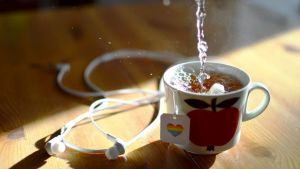 Rönnqvist ordnar regnbågscafé i Vasa på onsdagar kl. 18-21 i Folkhälsanhuset. En kaffekopp med ett äpple på. I koppen finns té, på tepåsens logo finns ett hjärta i regnbågsfärger.