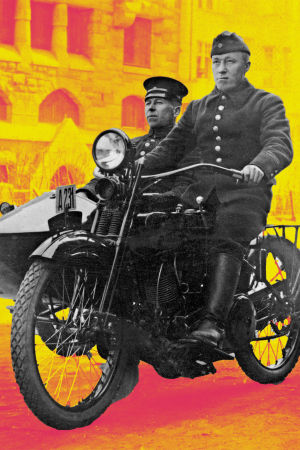 Palomies ja ruiskumestari ajavat Helsingin palolaitoksen sivuvaunullisella Harley-Davidson-moottoripyörän 1920-luvulla. Taustalla alipäällystön lapsia.