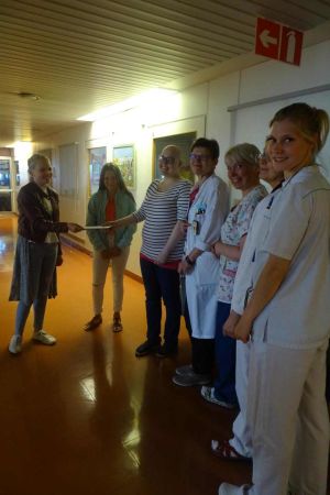 Nelli Kuortti, Nella Rautava, avdelningsöverläkare Päivi Lähteenmäki, handledare Kirsi Hellman och avdelningsskötare Riitta-Maija Hokkanen tog emot checken. Två flickor överräcker check åt sjukhuspersonal.