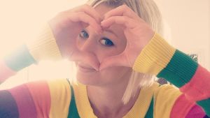 Esther Kazen tror att mycket handlar om rädsla. Esther Kazen iklädd en regnsbågsrandig tröja. Formar händerna som ett hjärta.