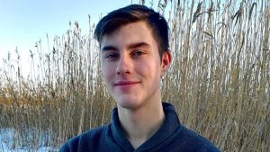 Benjamin Nedergård väntar ännu på om det blir nåt sommarjobb. benjamin nedergård i kofta med arrmarna i kors. han står utomhus på vintern med vass i bakgrunden.