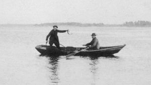 Traditionellt nätfiske i Hitis. traditionellt nätfiske, två män står i en båt och vittjar nät.
