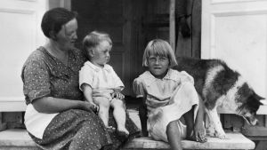 Marta Westerberg med barnen Inger och Rainer. En mor och två barn sitter på en stentrappa.