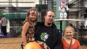 Besök i Björneborg. Borgåbon Kenneth Krohn med döttrana följde med Zoras dansshow.. Kenneth Krohn med barn framför roboten Zora.