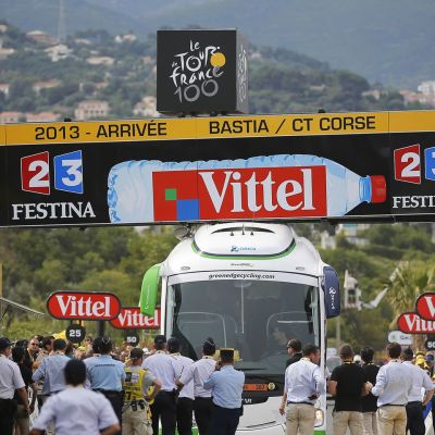 Bussi on jumissa Ranskan ympäriajon ensimmäisen etapin maaliviivan ajanottolaitteen alla.