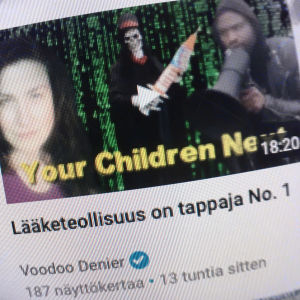 Ruutukaappaus Tokentube nettisivulta, jossa thumbnail-kuva videosta ja otsikko. Thumbnail-kuvassa pääkallonaamioon pukeutunut mies kantaa isoa rokotetta. Videon otsikossa lukee, että Lääketeollisuus on tappaja numero yksi.