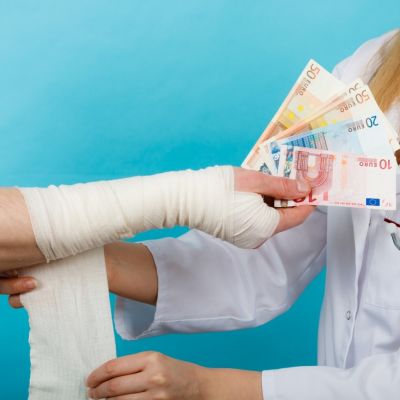 En kvinnlig doktor tar emot pengar för att sköta en patient.