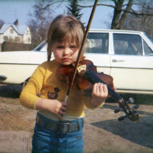 Musiken har alltid varit närvarande i Anna-Marias liv. Anna-Maria Helsing som liten flicka med en fiol på axeln.