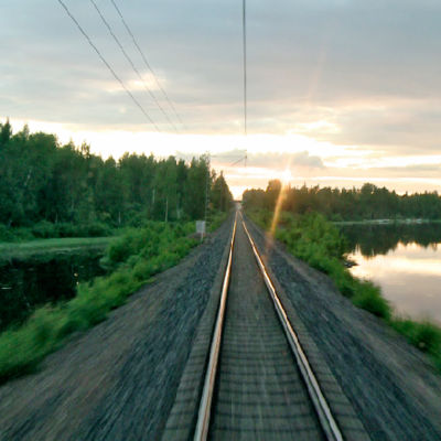 Rautatiekiskot kesäyönä junan veturista kuvattuna.