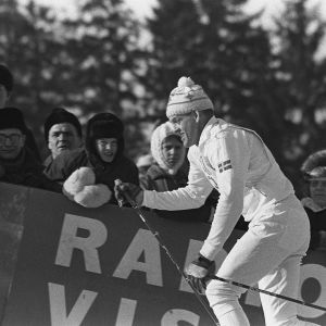 Salpausselän kisat. Hiihtokilpailut: hiihtäjä nousee ylämäkeä katsojien edessä (1960-luku)