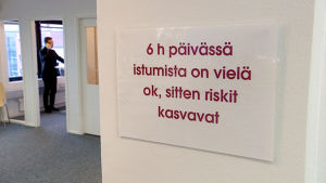 Taulu toimiston seinällä: 6h päivässä istumista on vielä ok, sitten riskit kasvavat