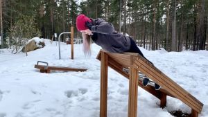 Reportern testade utegymmet uppe på Kvarnåsen. En kvinna i pink mössa och mörka kläder tränar ryggmuskler på en träställning utomhus. Det är snö på marken. I bakgrunden finns andra ställningar.