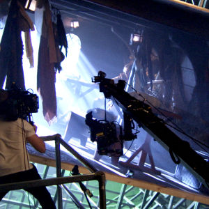 En kameraman filmar en scen i en kuliss som påminner om ett skepp.