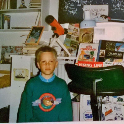 Frank Martela lapsena huoneessaan, taustalla kaukoputki ja tietokirjoja.