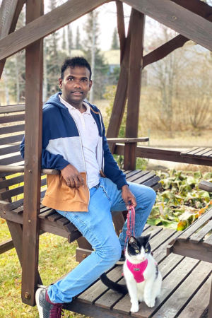 Det gäller att se glädjen i det lilla. Venkat brukar ta ut katten på upptäcktsfärd. En man sitter i en trädgårdsgunga. En katt i sele sitter bredvid honom.