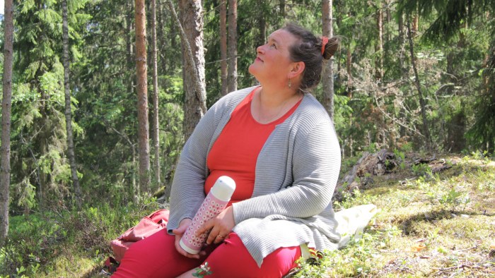 psykologi Liisa Uusitalo-Arola metsäretkellä nauttii eväitä iloisena