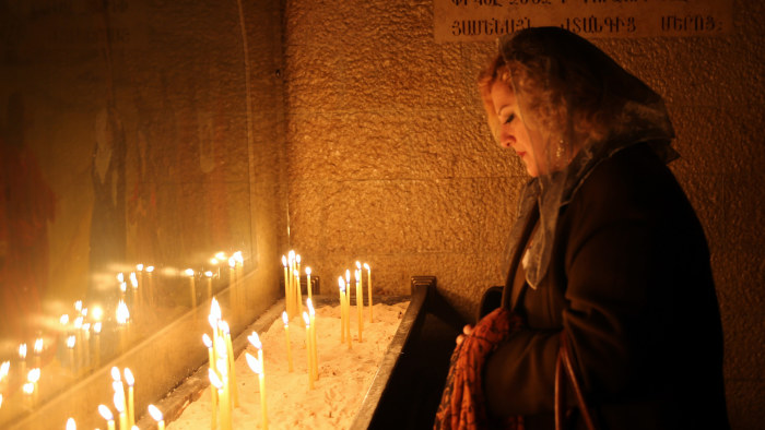 En armenisk kvinna tänder ljus i n kyrka för att hedra minnet av armenierna som dödades i det Osmanska riket mellan år 1915 och år 1917