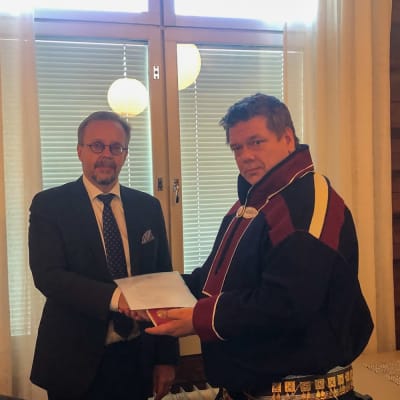Korkeimman hallinto-oikeuden presidentti Tatu Leppänen ojentaa kunniamitalin Saamelaiskäräjien II varapuheenjohtaja Leo Aikiolle 9.9.2021.