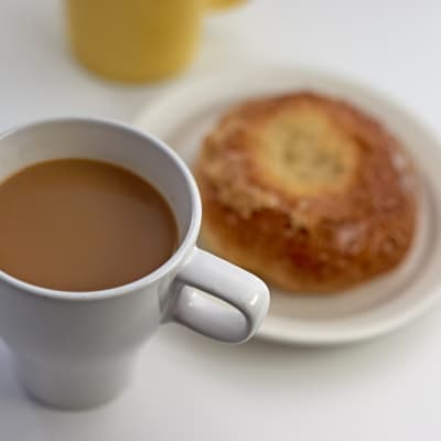 A mug of coffee and a bun.