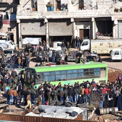 människor köar till en buss för att bli evakuerade i östra aleppo
