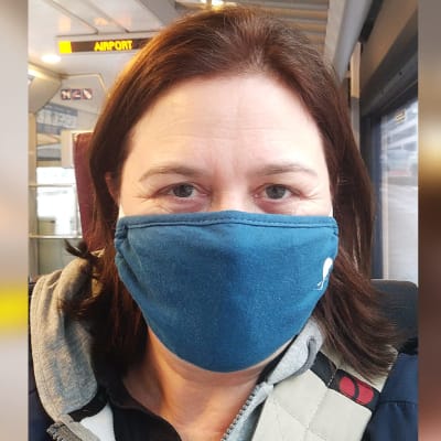 Kapellimestari Anna-Maria Helsing lentokenttäjunassa maski kasvoilla.