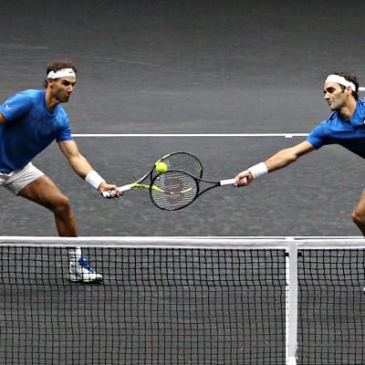 Nadal och Federer på samma sida nätet, kämpar om bollen