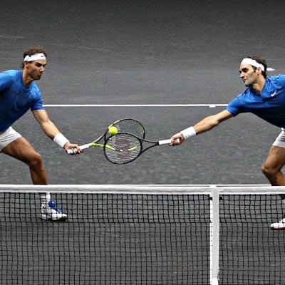 Nadal och Federer på samma sida nätet, kämpar om bollen