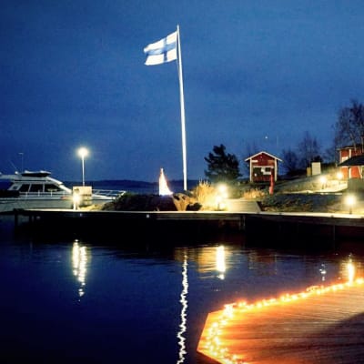 En stor motorbåt förtjöjd vid en upplyst brygga på Örö.