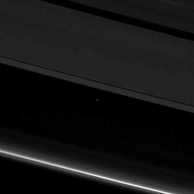 Saturnus ringar med jorden i bakgrunden.