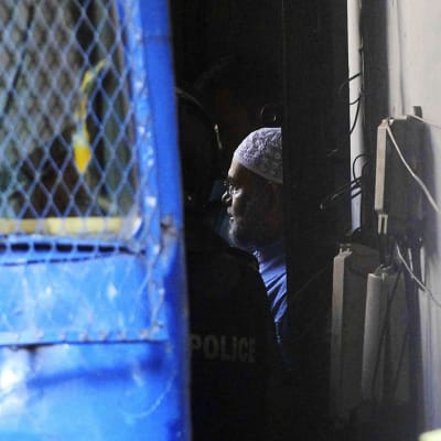 2. marraskuuta 2014 päivätyssä kuvassa bangladeshiläistä islamistijohtajaa Mir Quasem Alia siirretään viranomaisten huomaan oikeusistuntonsa päätyttyä Dhakassa, Bagladeshissä.