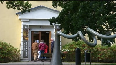 Ihmiset menevät keltaiseen rakennukseen sisälle.