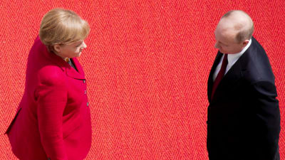 Angela Merkel och Vladimir Putin står mot varandra.